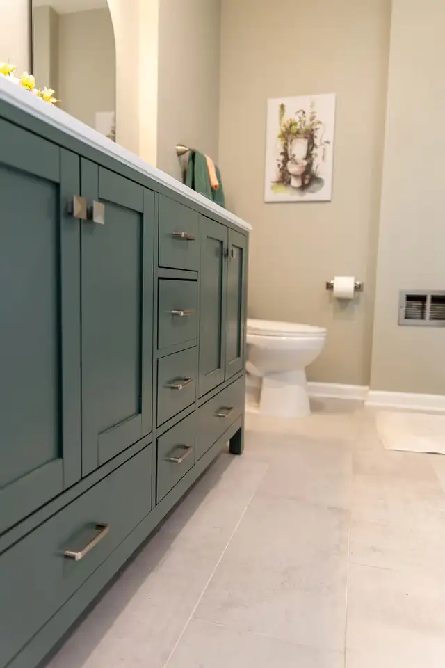 Gurnee bathroom remodel with a deep green Shaker vanity, white top and light porcelain floor