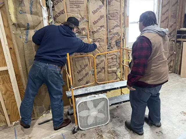 Rohrer crew members installing insulation and framing during a remodel
